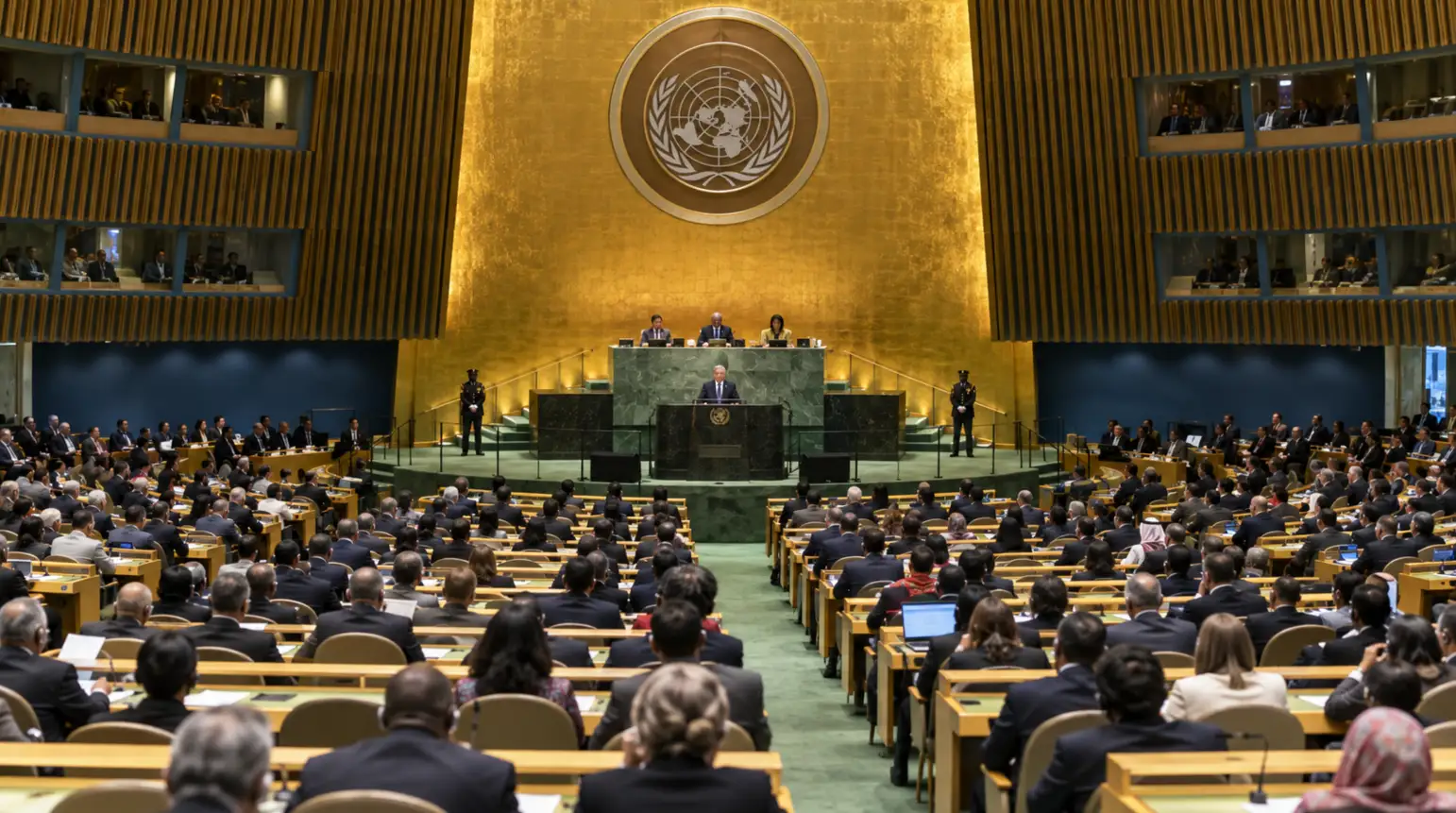Rows of delegate desks and microphones inside the United Nations General Assembly Hall.