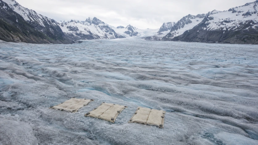 White wool covers spread over a small marked section of a mountain glacier in Switzerland.